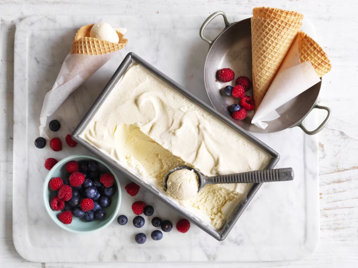 Vanilla ice cream with berries and ice cream cones surrounding
